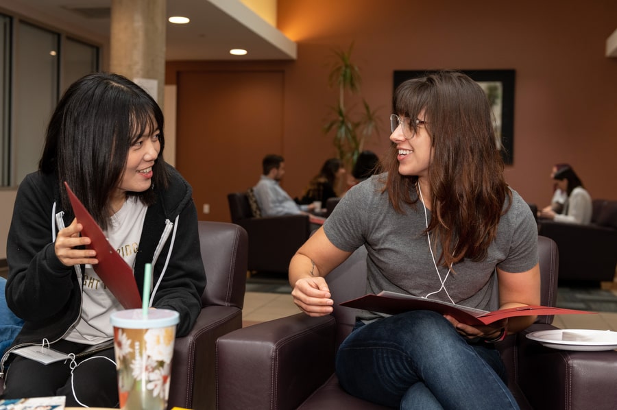 Graduate students sitting, working, and chatting