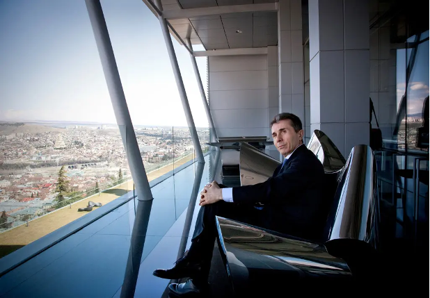 Ivanishvili sits at a plate glass window overlooking a city