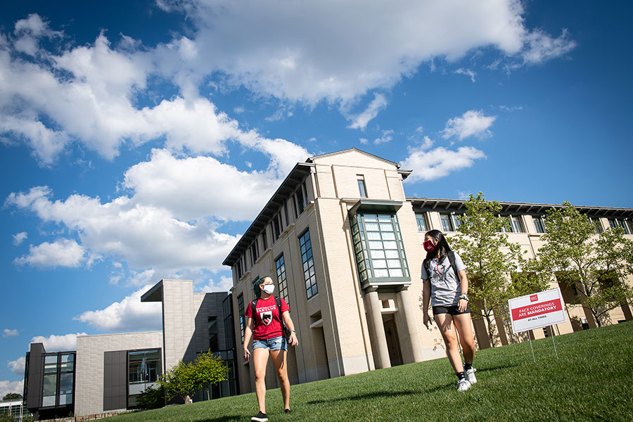 Two students in CMU t-shirts walk across campus.