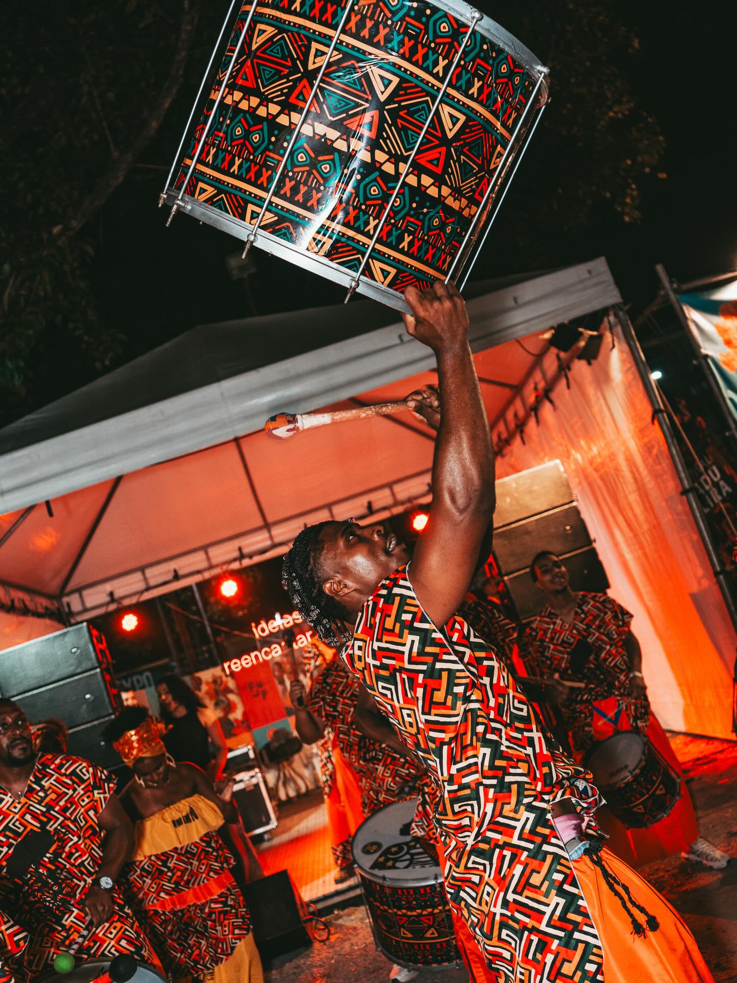 man stands with drum above his head