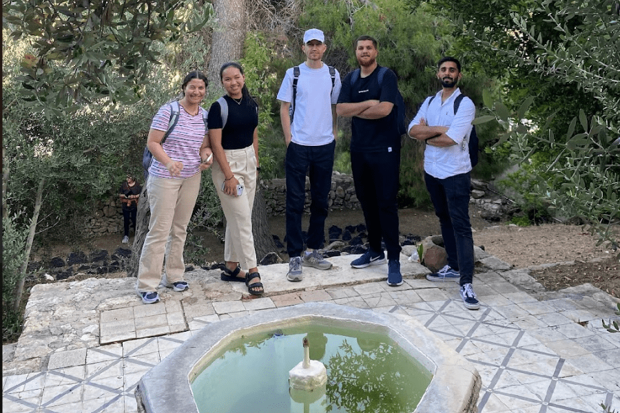 A group of 5 students pose in front of a fountain in a garden in Amman, Jordan