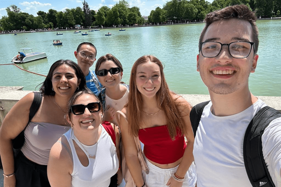 Six students take a selfie in front of a large park fountain in Madrid, Spain