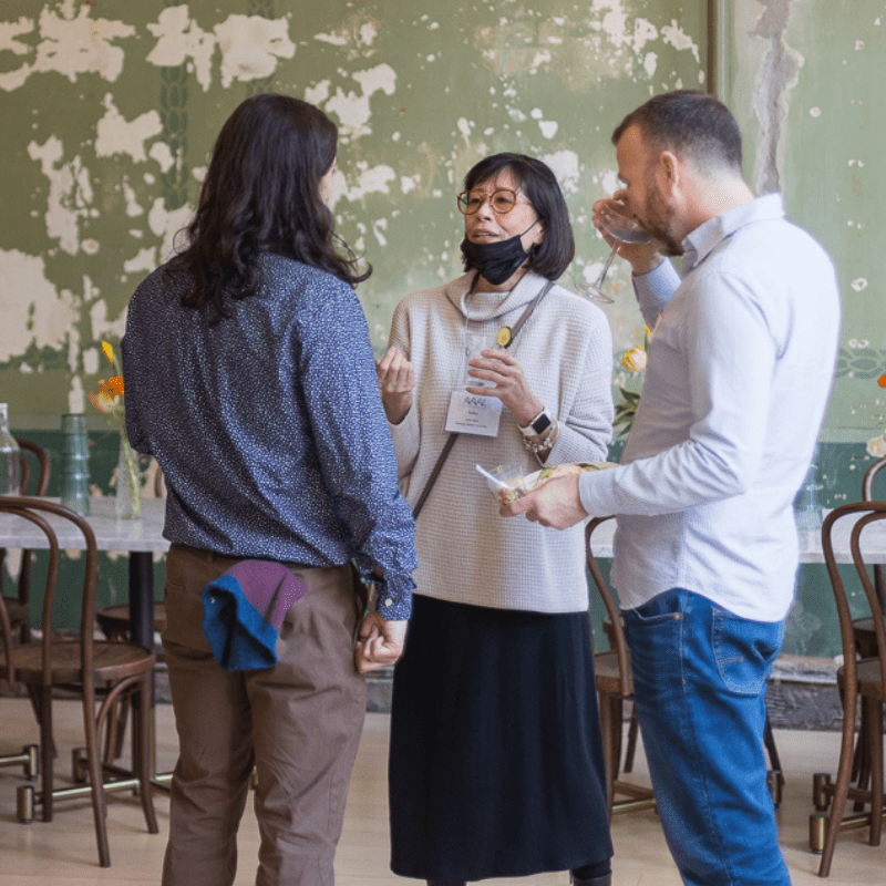 Keiko Koda speaks with two people at a reception