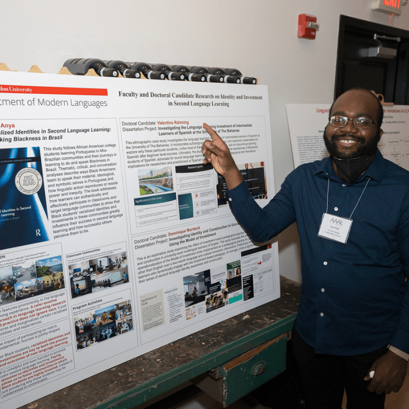 Student Valentino Rahming stands in front of his research poster