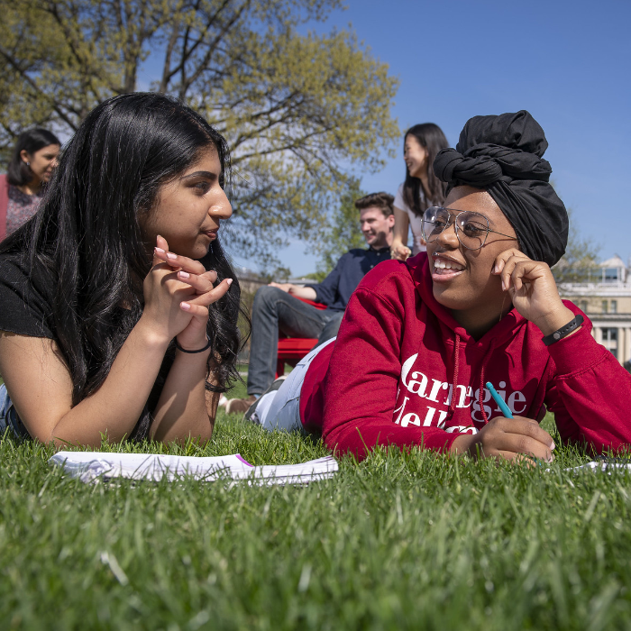 CMU students sit on a field and talk