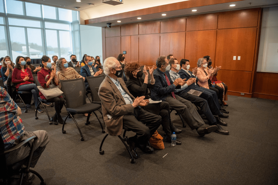 Barbara Freed and other audience members, masked, applauding at an event