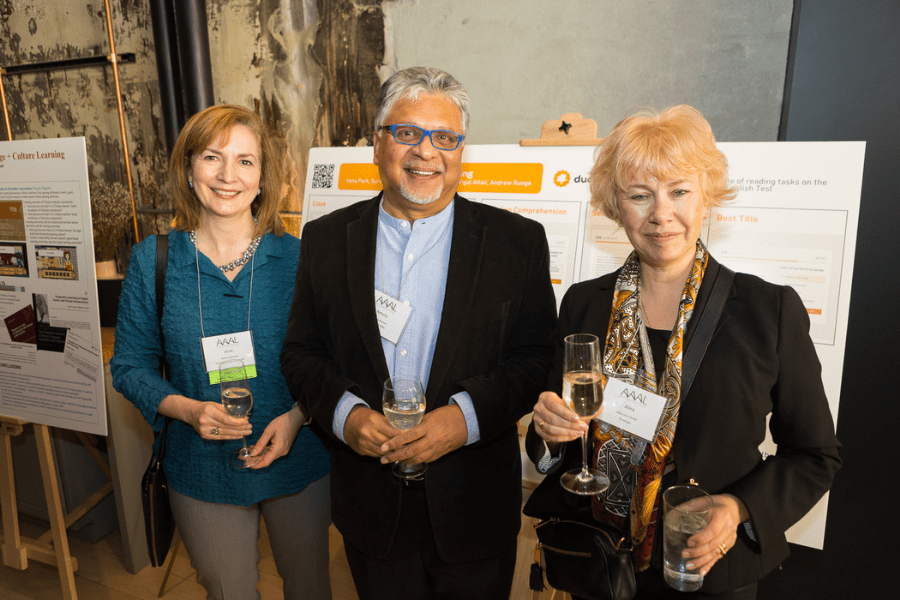 Anne Lambright, Antony Kunnan, and Alina von Davier pose for a photo in front of research posters