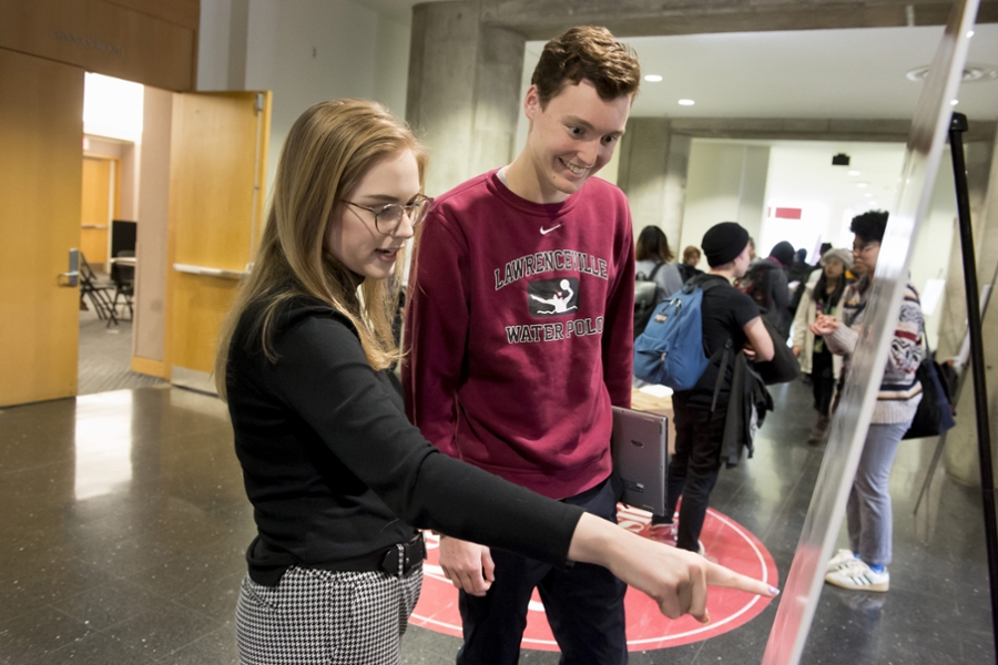 Two students discussing a poster during the poster session.