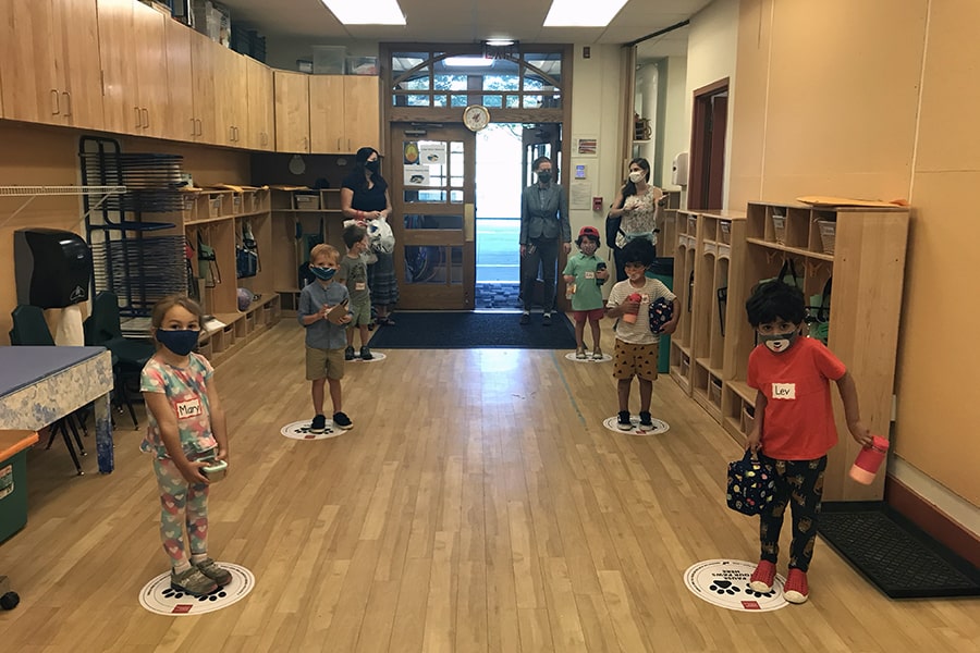 Children wearing masks, standing on Scotty prints