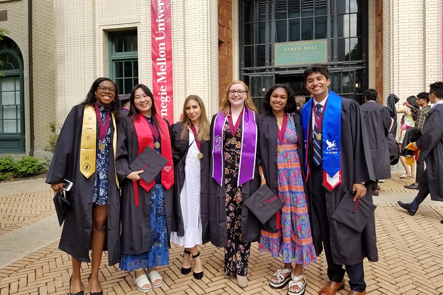 6 students at commencement in front of Baker Hall