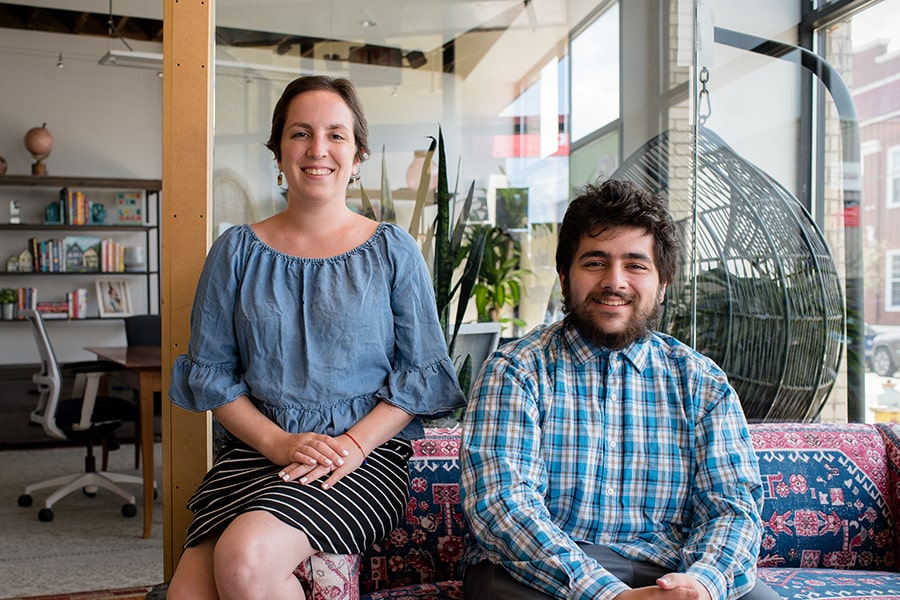 A CMU student poses on a sofa beside an internship mentor
