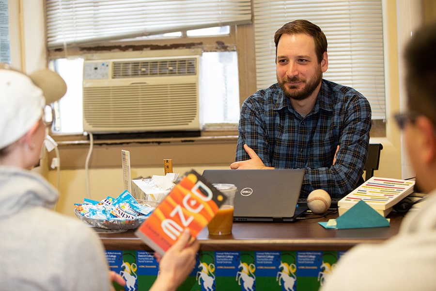 Andrew Ramey talks with two students