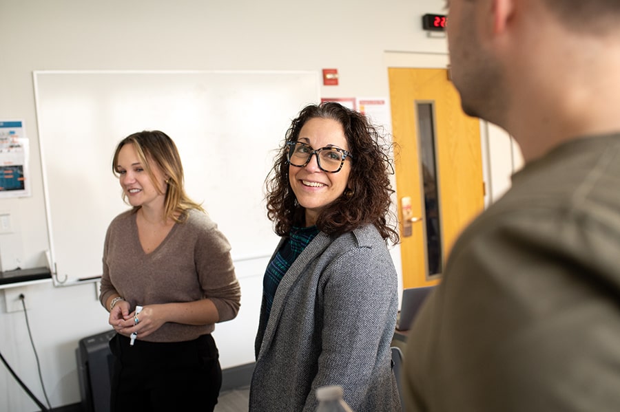 Daniel Wetzel laughs during a discussion with two students