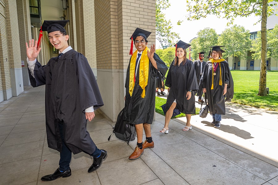 Students smile and wave as they enter the PBK initiation ceremony