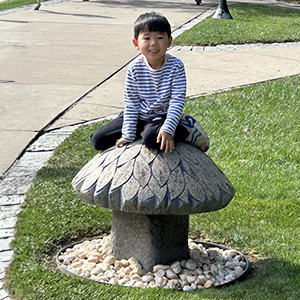 A child sits atop a mushroom statue