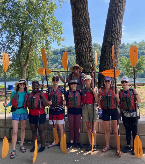 Students pose with lifejackets and paddles