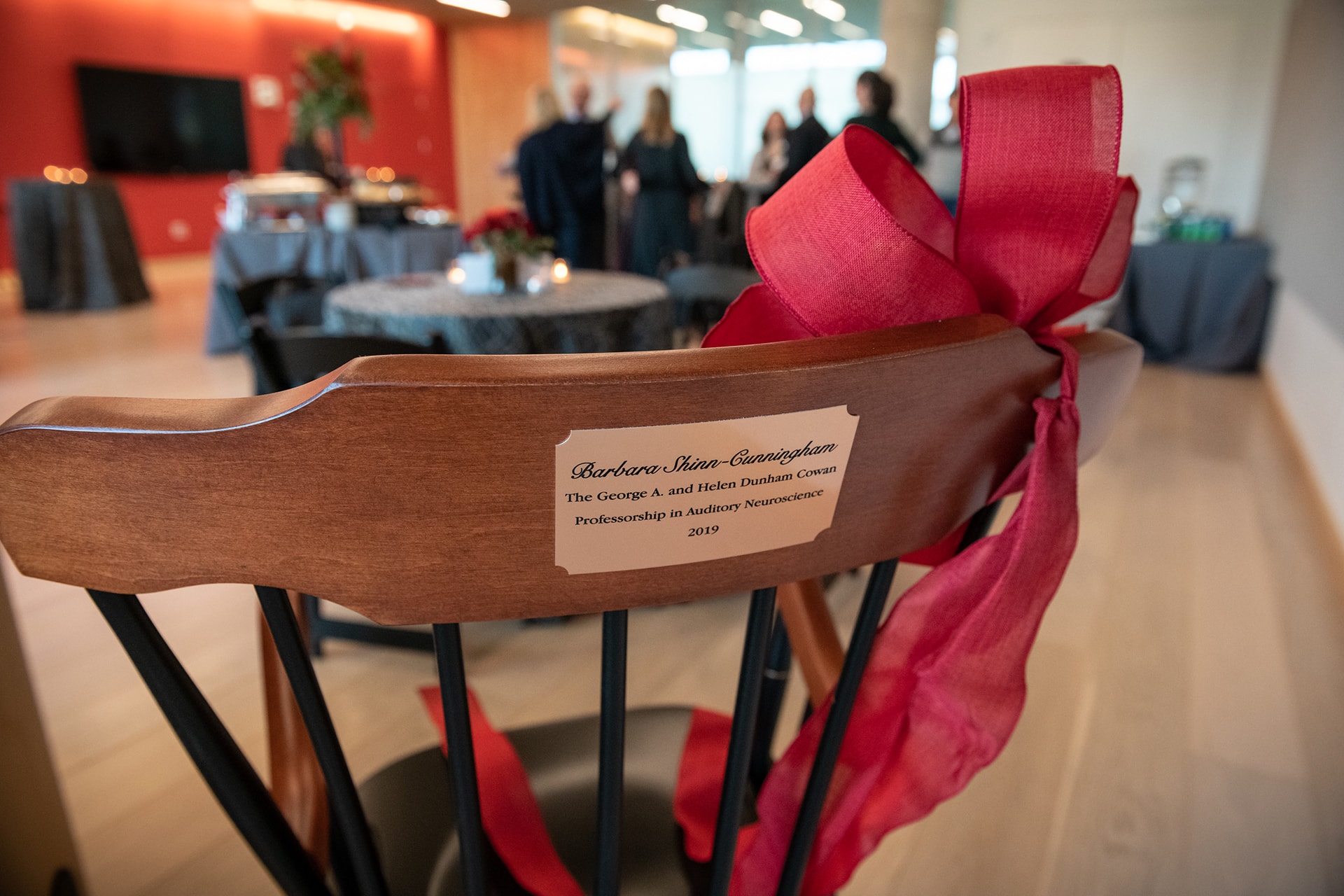 the back of a chair with the professorship plaque attached to it