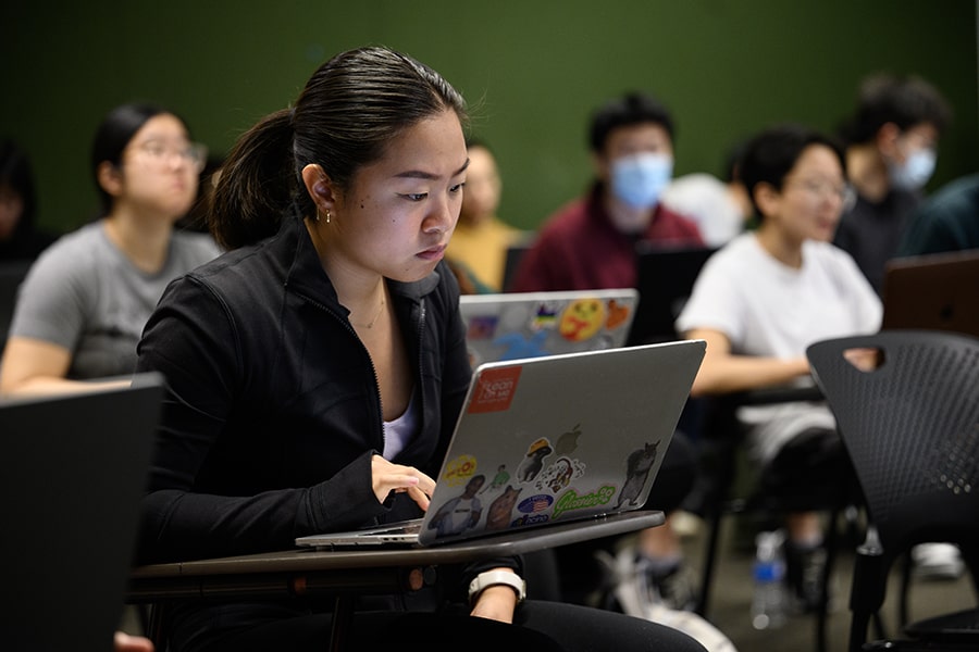 A student using a laptop in a classroom