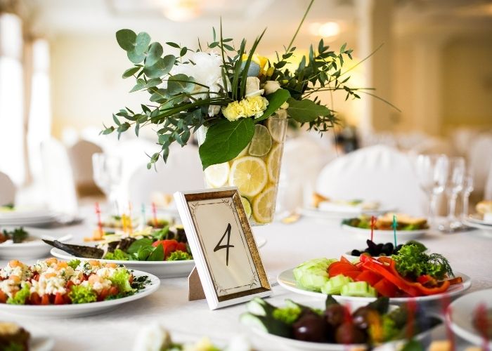 table set for an upscale event with plated food and floral centerpieces