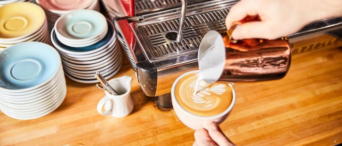 barista making a latte with leaf-art