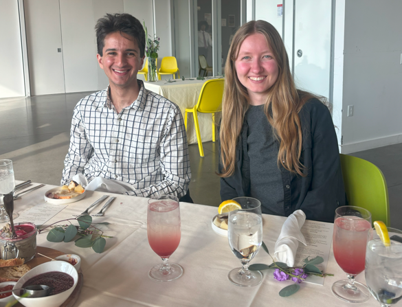 two students sitting at a table smiling