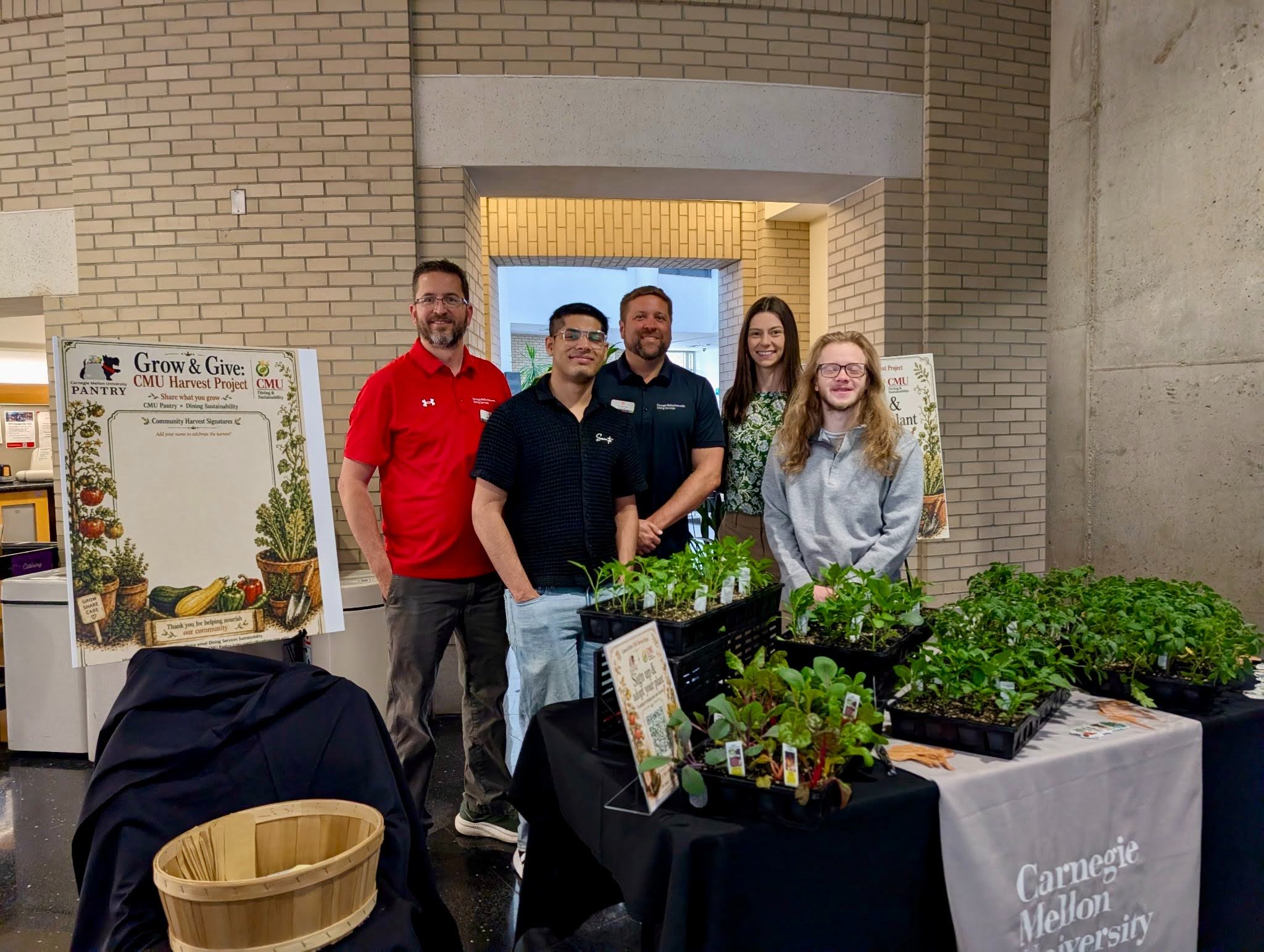 Dining staff photo standing in front of vegetable seedling plants on a table