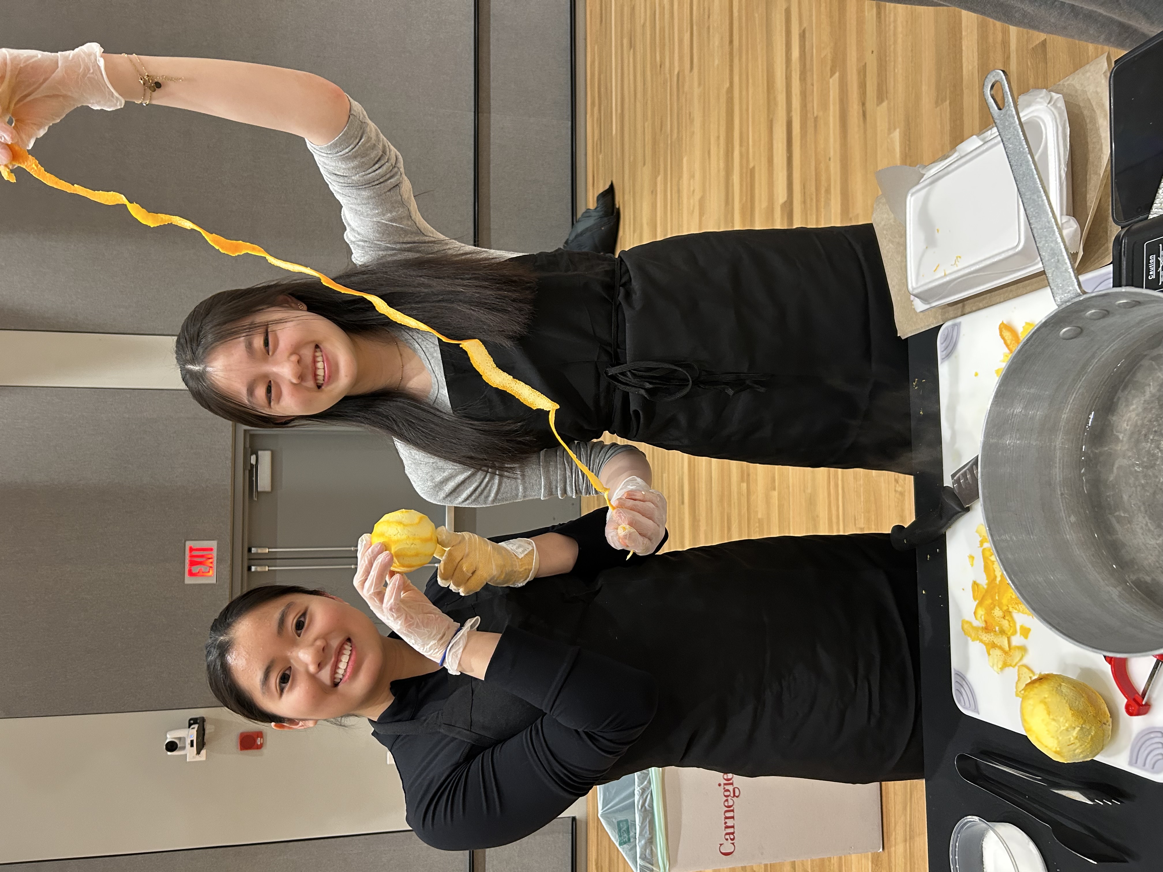 two students cooking with oranges