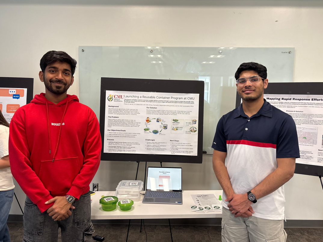 two students in front of presentation at Impact CMU event