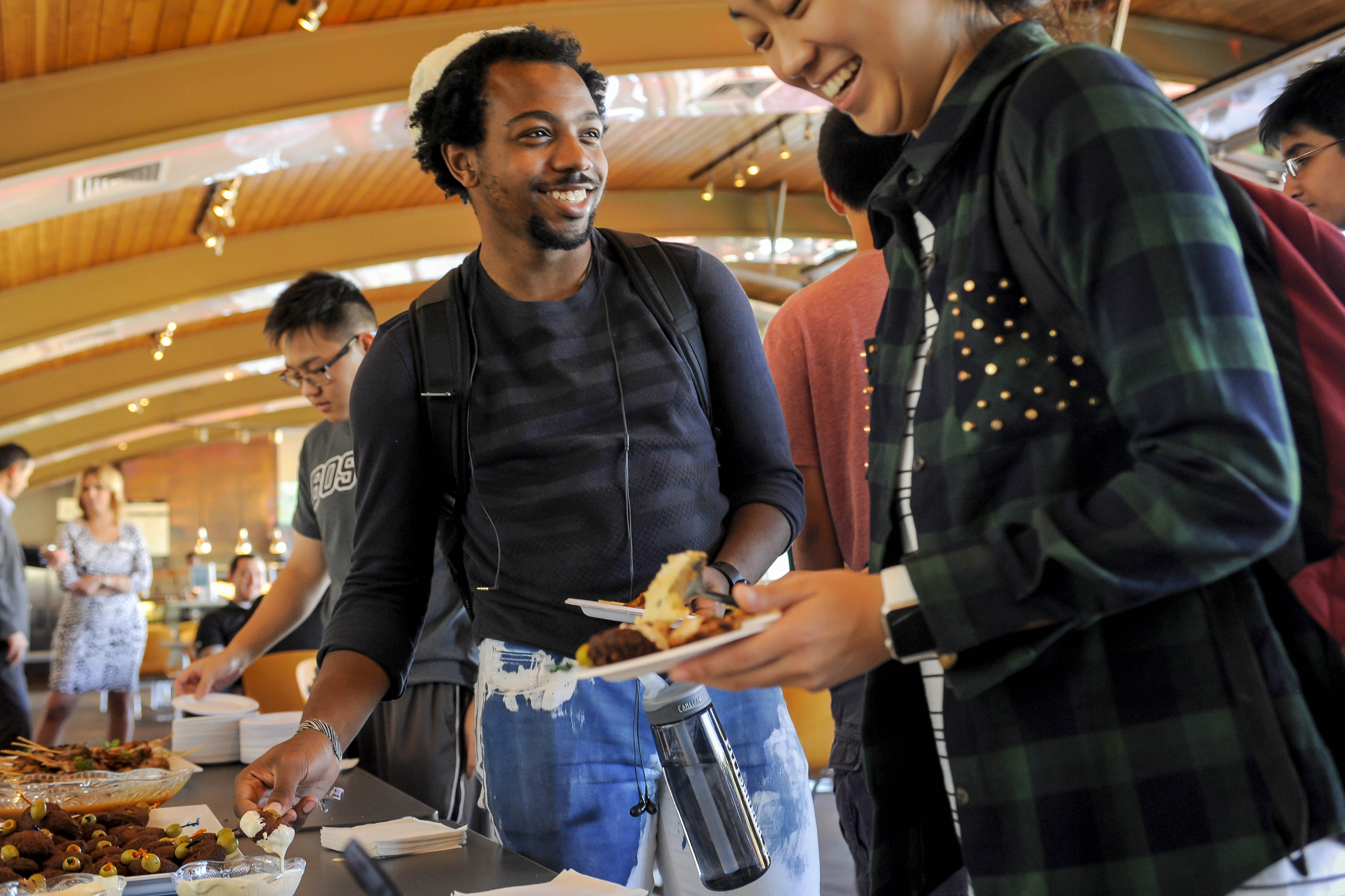 Two students smiling and eating food 