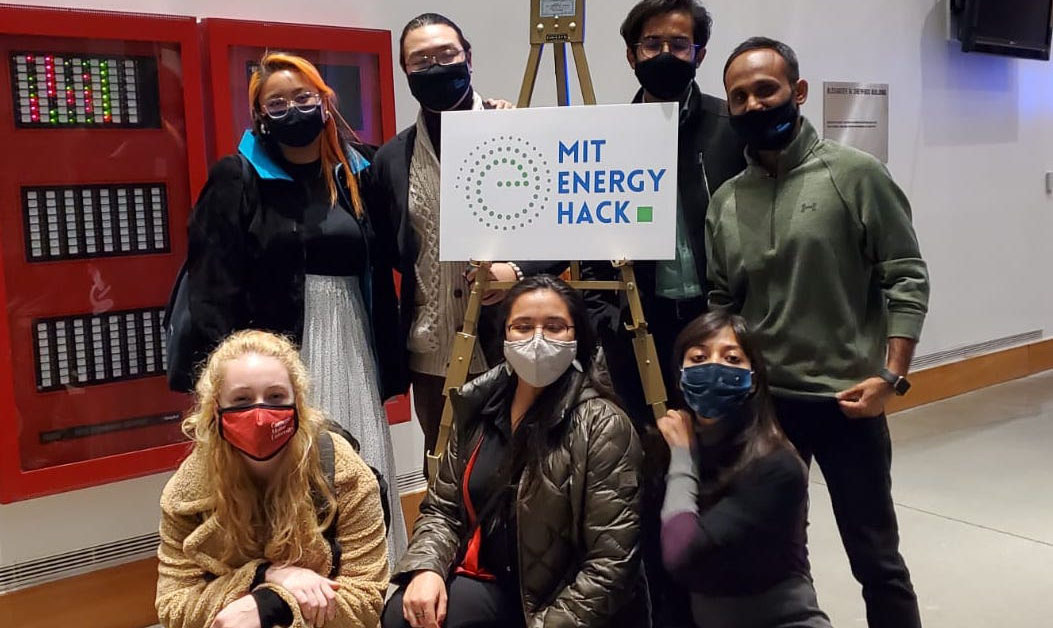 CMU Graduate students posing in front of MIT Energy Hack Sign