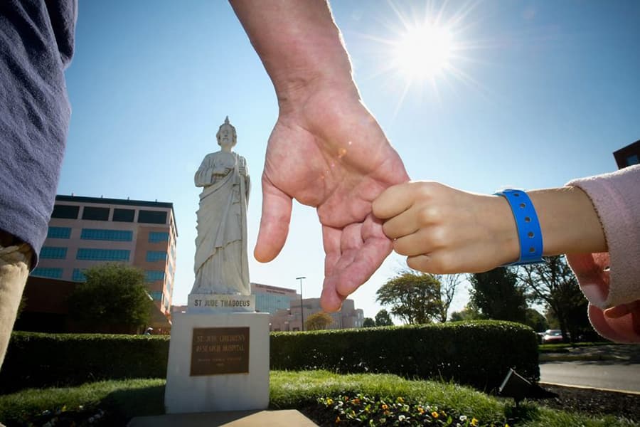 Hands clasped in front of St. Jude statue