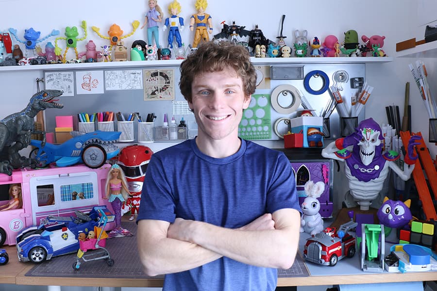 Josh Finkle at his desk, surround by toys