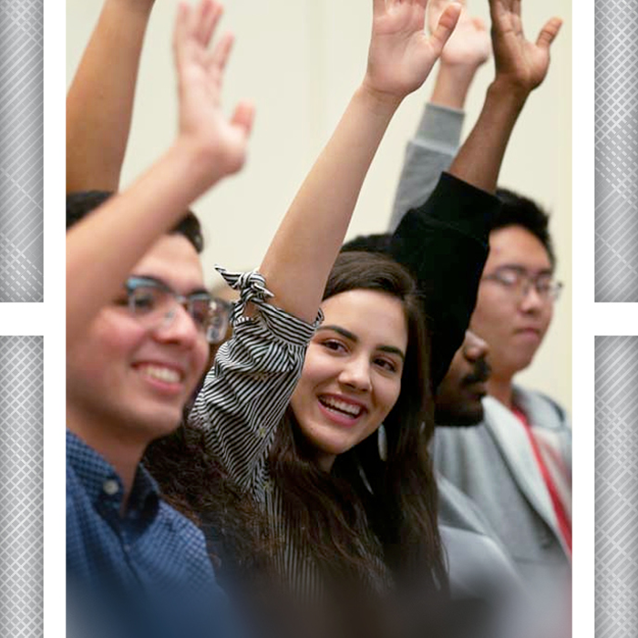 students raising hands in class