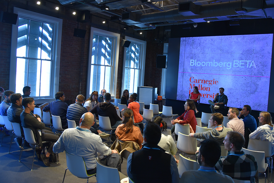 Photo of seated audience watching presentation