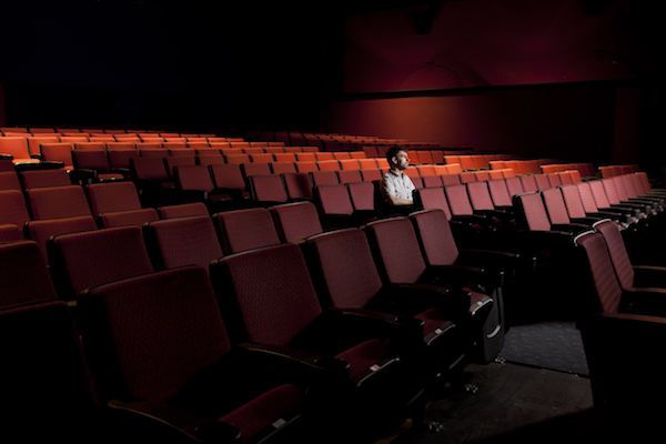 A man sits alone in a theater