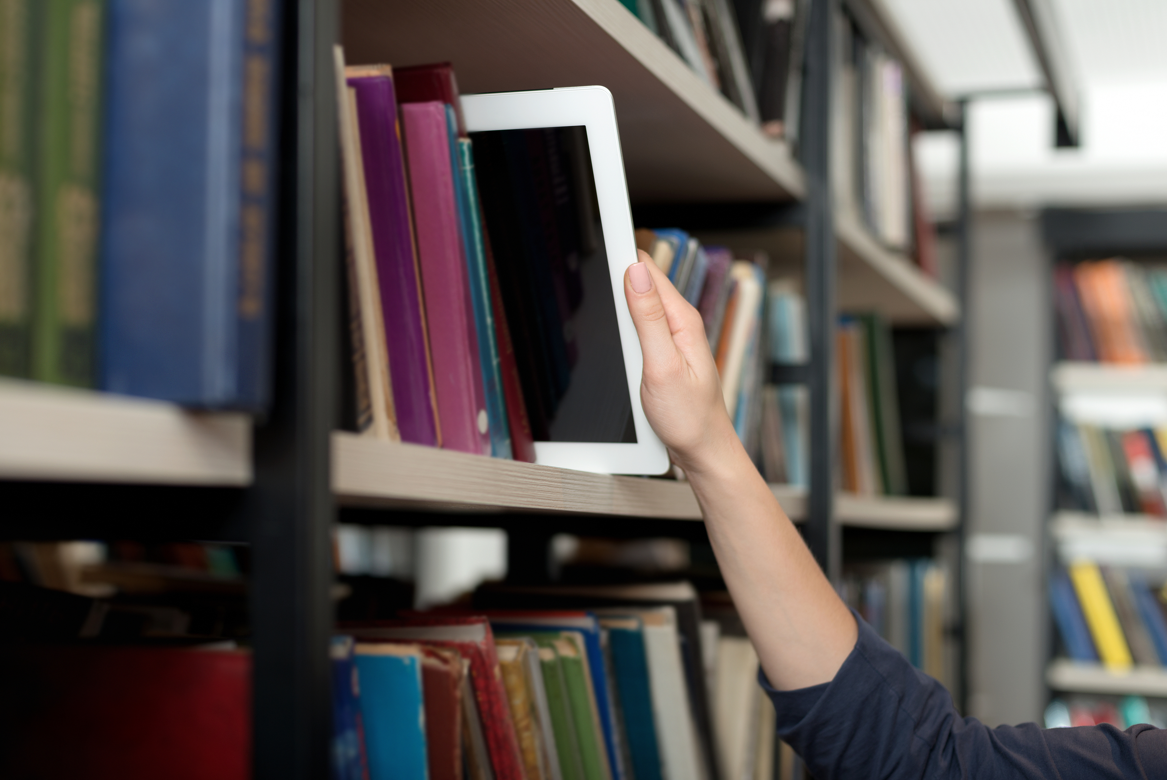 A tablet on a bookshelf