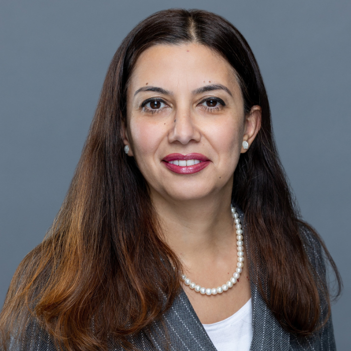 Women with long hair wearing pearls, white shirt with a grey blazer