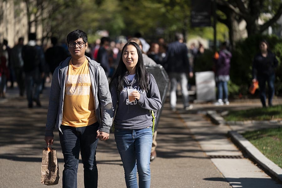 photo of two student walking through campus 