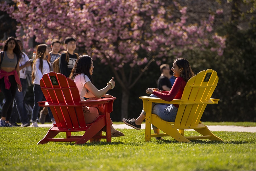 photo of CMU students sitting in chairs chatting with one another on the cut