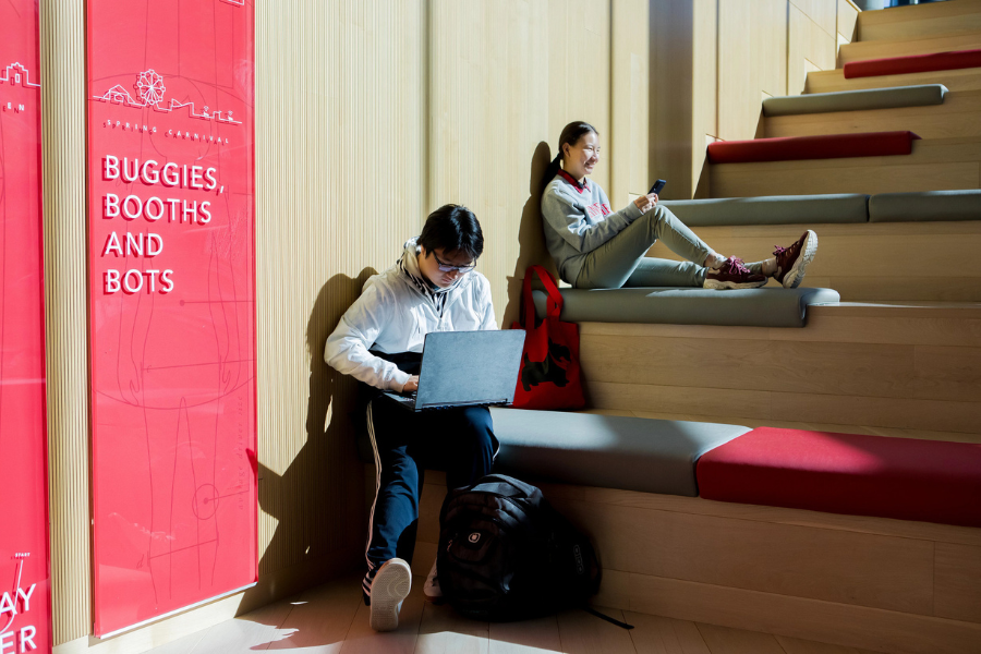 two students sitting on a staircase in Tepper Business School