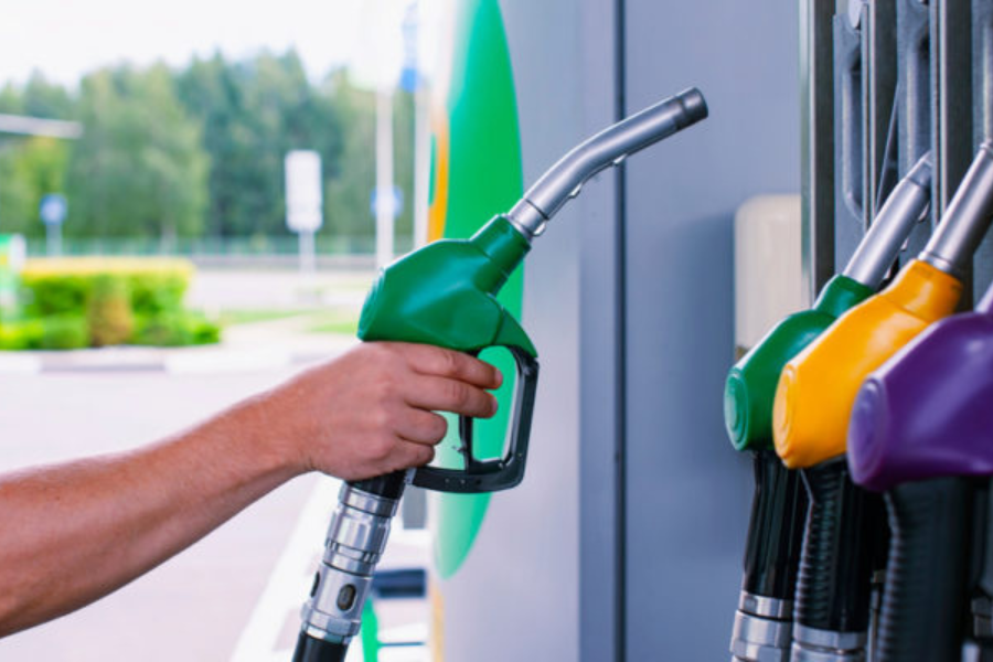 person picking up a gas pump at a gas station