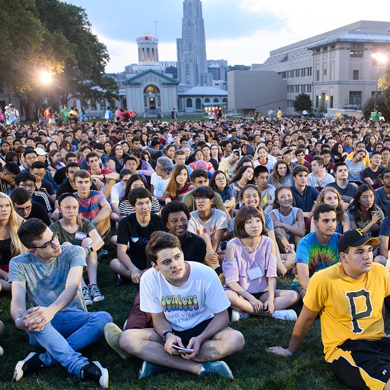Photo of a large group of students sitting on the Cut