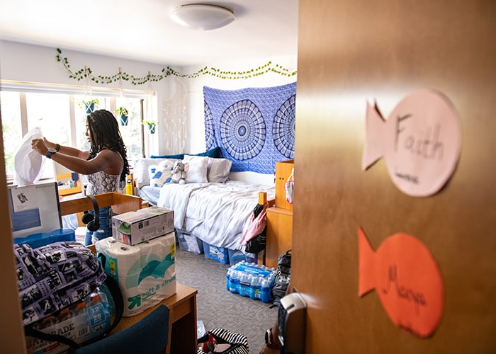 CMU student unpacking things in their residence hall room