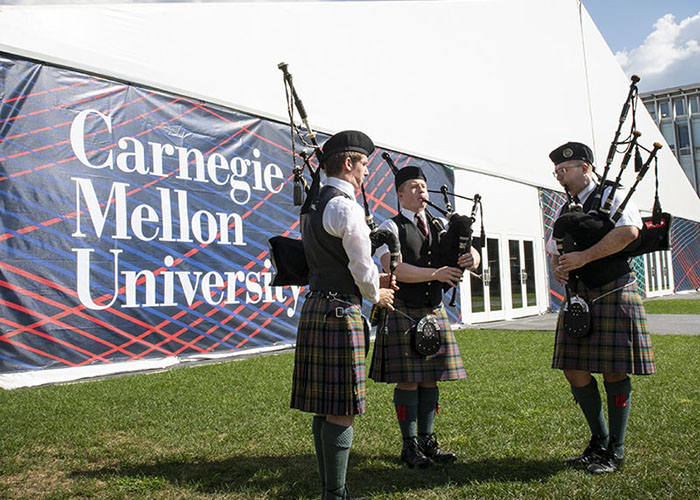 Photo of CMU bagpipers practicing outside of the tent