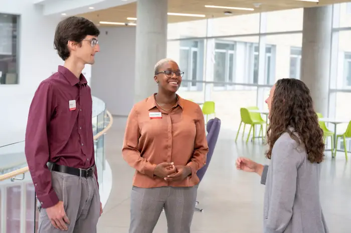 Two Rales Fellows students speak with a faculty member.