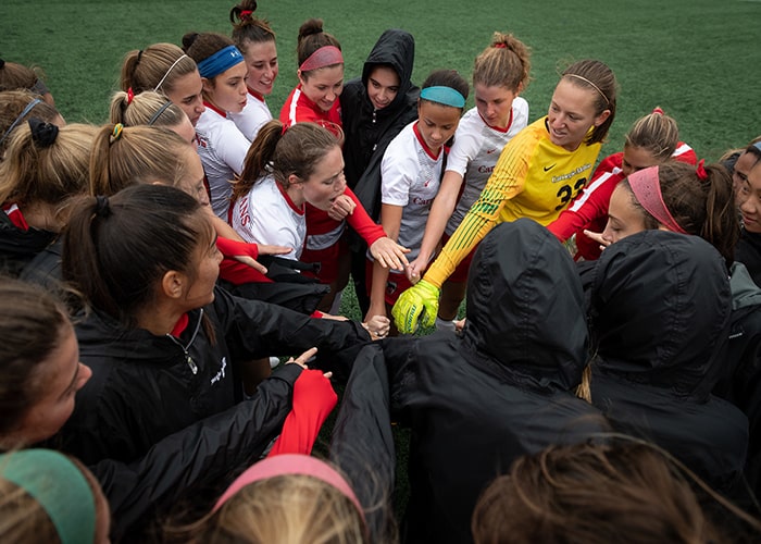 Women's soccer team in a huddle