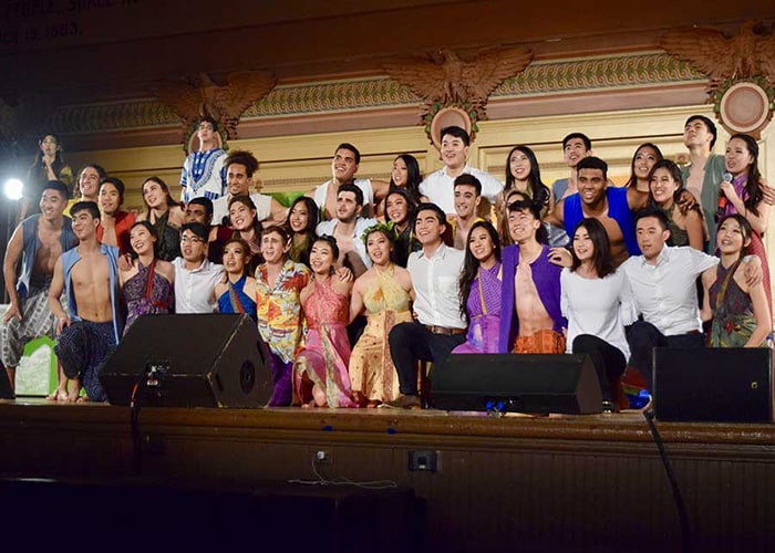 students posing on stage at Greek Sing competition