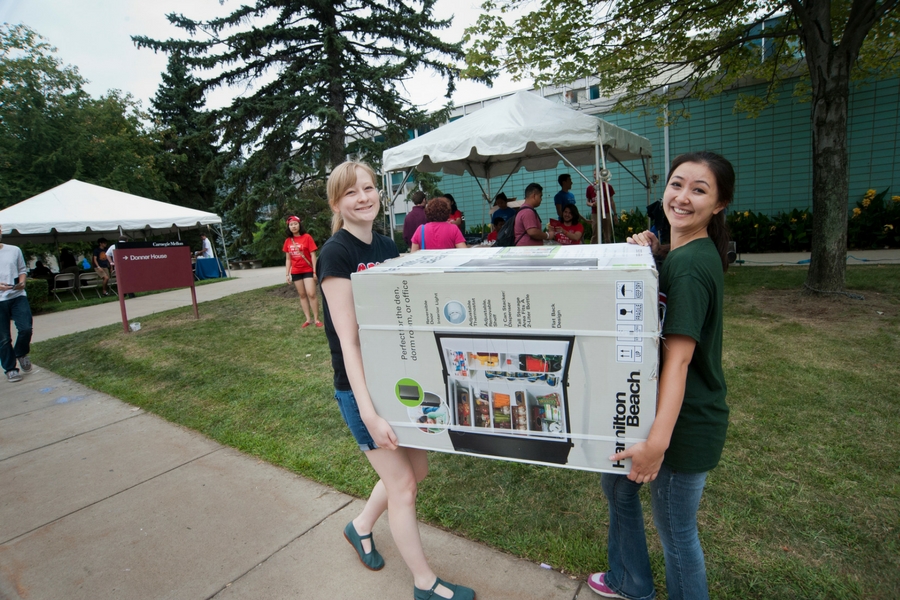 Photo of students carrying items 