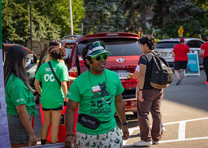 a student in green helps students move into Stever House