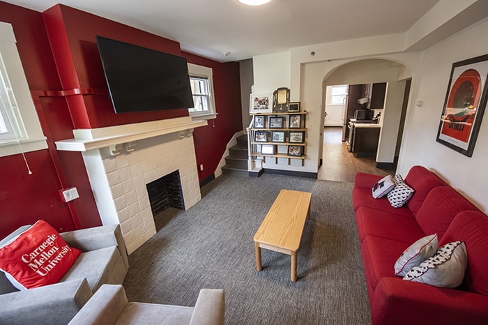 Spirit House Living Room (looking toward the kitchen) - red couch shelves and picture frames tv and white mantle